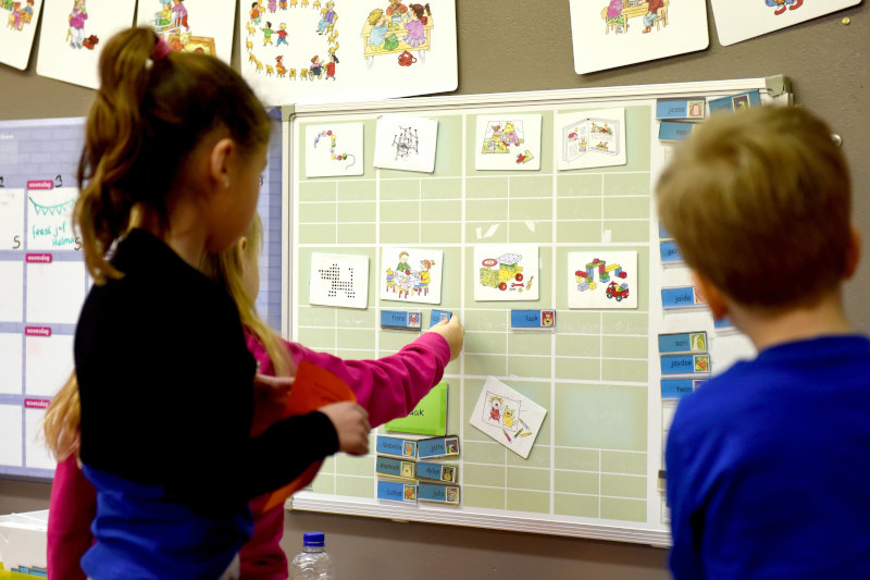 Preschool kids looking at an activity board